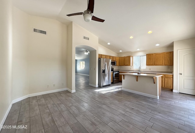 2898 W Simplicity Dr, Tucson, AZ 85741 - kitchen featuring stainless steel appliances, a ceiling fan, lofted ceiling, light countertops, and a kitchen breakfast bar