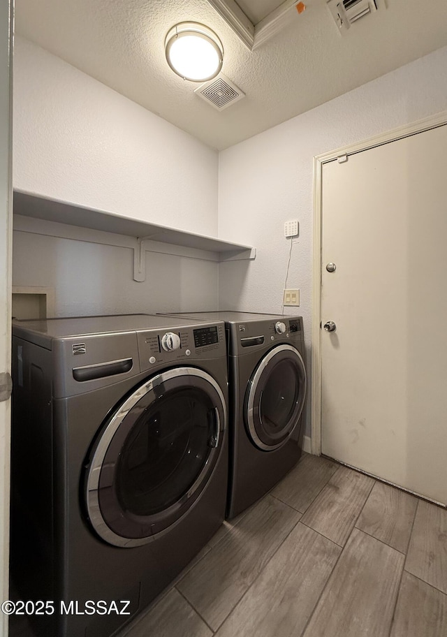 2898 W Simplicity Dr, Tucson, AZ 85741 - laundry area featuring separate washer and dryer, wood tiled floors, and a textured ceiling