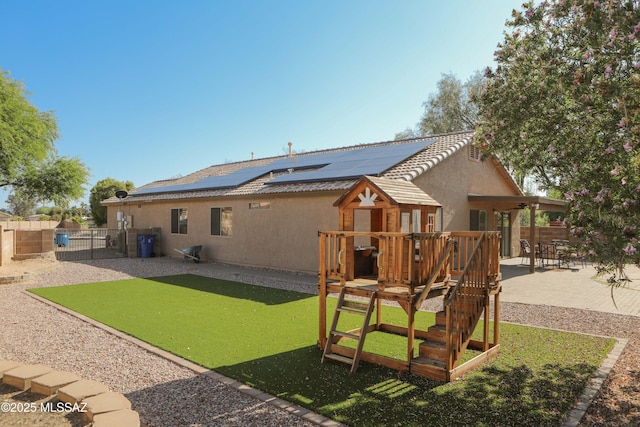 2898 W Simplicity Dr, Tucson, AZ 85741 - rear view of property with a patio area, stucco siding, roof mounted solar panels, a fenced backyard, and a gate