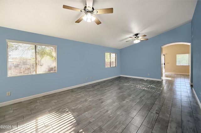 2898 W Simplicity Dr, Tucson, AZ 85741 - empty room with a ceiling fan, arched walkways, plenty of natural light, vaulted ceiling, and dark wood-type flooring