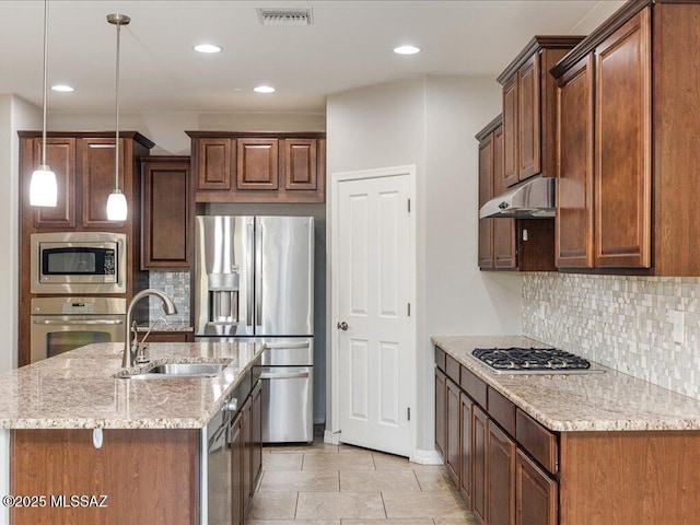 3872 W Sonoma Ranch Pl, Marana, AZ 85658 - kitchen with stainless steel appliances, under cabinet range hood, light stone counters, backsplash, and pendant lighting