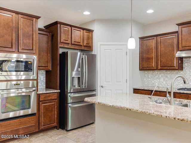 3872 W Sonoma Ranch Pl, Marana, AZ 85658 - kitchen featuring appliances with stainless steel finishes, decorative backsplash, light stone counters, hanging light fixtures, and recessed lighting
