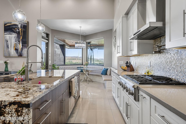 379 Camino A Las Casitas, Rio Rico, AZ 85648 - kitchen featuring wall chimney exhaust hood, stainless steel gas cooktop, tasteful backsplash, white cabinetry, and light tile patterned flooring