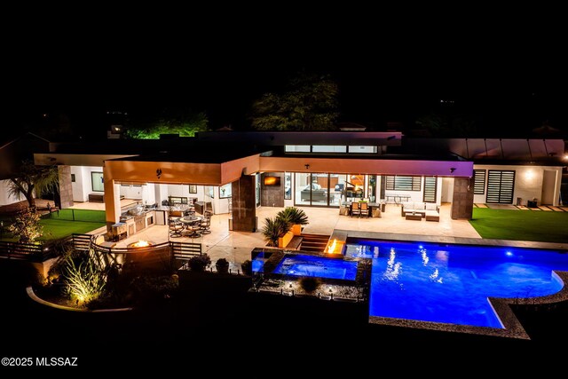 379 Camino A Las Casitas, Rio Rico, AZ 85648 - pool at night with a patio area, an outdoor pool, an in-ground hot tub, and an outdoor living space with a fire pit