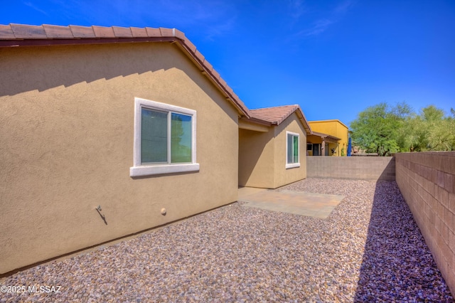 8348 N Mountain Stone Pine Way, Tucson, AZ 85743 - view of side of home with stucco siding, a fenced backyard, a tiled roof, and a patio area