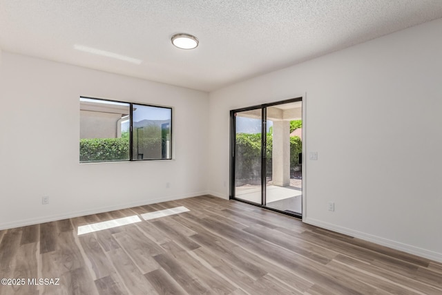 64161 E Santa Catalina Ct, Saddlebrooke, AZ 85739 - empty room with wood finished floors and a textured ceiling