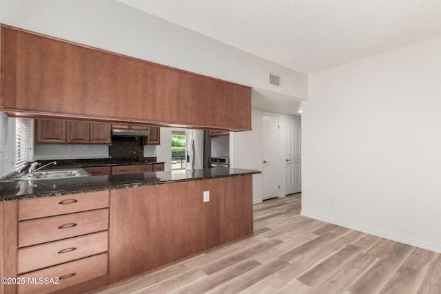 64161 E Santa Catalina Ct, Saddlebrooke, AZ 85739 - kitchen with a peninsula, light wood finished floors, stainless steel refrigerator with ice dispenser, under cabinet range hood, and dark stone counters