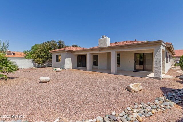 64161 E Santa Catalina Ct, Saddlebrooke, AZ 85739 - rear view of property featuring a chimney, a patio area, stucco siding, and a tiled roof