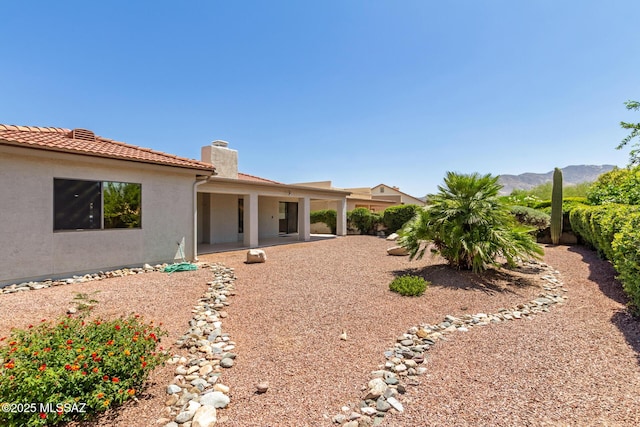 64161 E Santa Catalina Ct, Saddlebrooke, AZ 85739 - back of property with a chimney, stucco siding, a patio area, a mountain view, and a tile roof