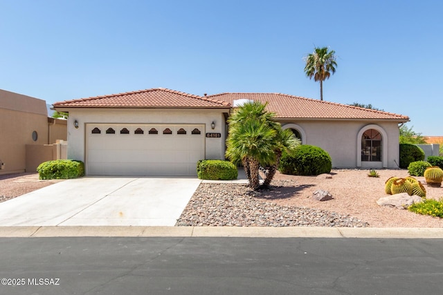 64161 E Santa Catalina Ct, Saddlebrooke, AZ 85739 - mediterranean / spanish-style house featuring stucco siding, concrete driveway, an attached garage, and a tiled roof