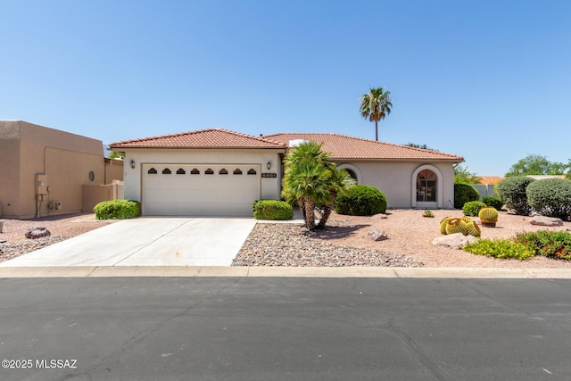 64161 E Santa Catalina Ct, Saddlebrooke, AZ 85739 - mediterranean / spanish-style home with a garage, stucco siding, driveway, and a tiled roof