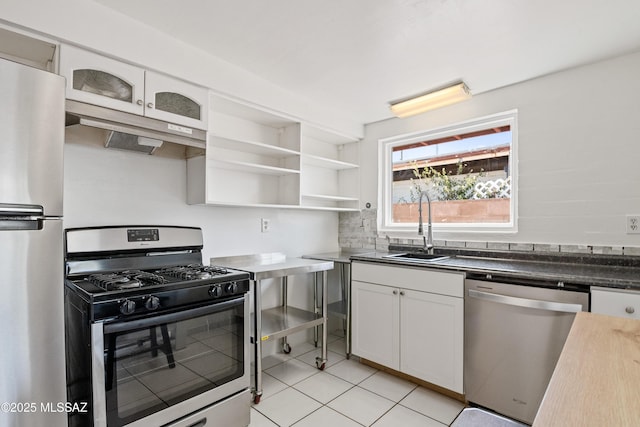 1818 E Mitchell St, Tucson, AZ 85719 - kitchen featuring appliances with stainless steel finishes, under cabinet range hood, white cabinets, light tile patterned flooring, and open shelves