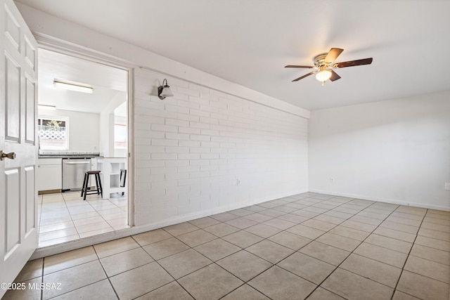 1818 E Mitchell St, Tucson, AZ 85719 - spare room featuring light tile patterned floors, ceiling fan, and brick wall