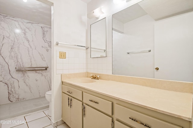 1818 E Mitchell St, Tucson, AZ 85719 - full bath featuring vanity, a marble finish shower, tile walls, and tile patterned flooring