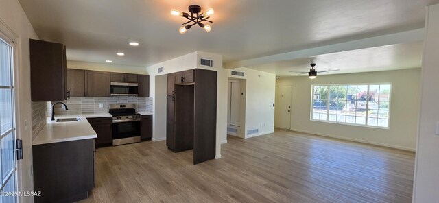 2215 E Bantam Rd, Tucson, AZ 85706 - kitchen with appliances with stainless steel finishes, dark brown cabinets, light countertops, decorative backsplash, and light wood-style floors