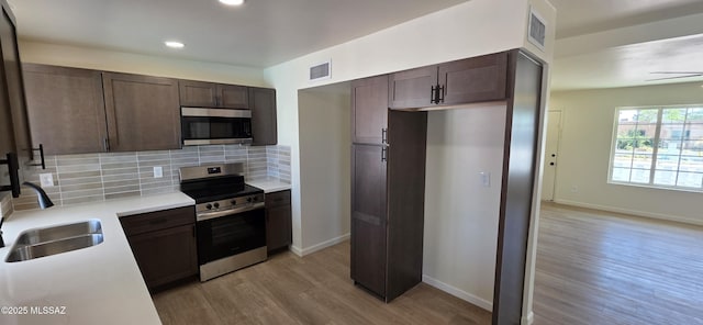 2215 E Bantam Rd, Tucson, AZ 85706 - kitchen featuring stainless steel appliances, light wood-type flooring, dark brown cabinetry, tasteful backsplash, and recessed lighting