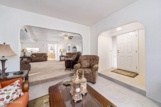 5760 S Stewart Blvd, Tucson, AZ 85706 - living area featuring arched walkways, light tile patterned floors, light carpet, and ceiling fan