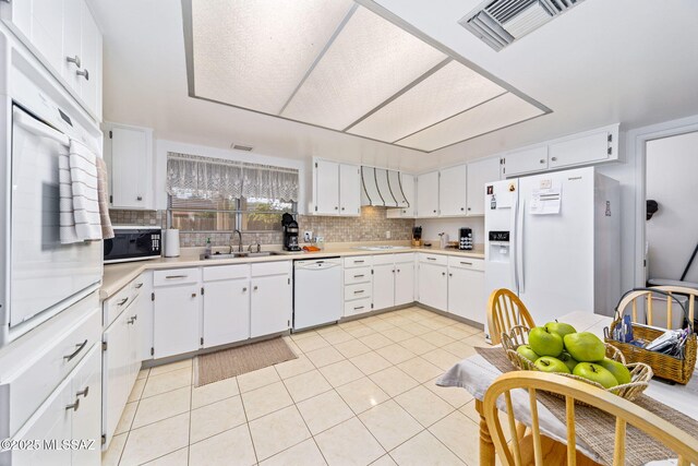 5760 S Stewart Blvd, Tucson, AZ 85706 - kitchen with white appliances, tasteful backsplash, light countertops, light tile patterned floors, and white cabinets