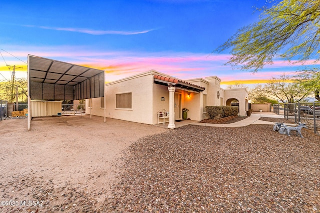 5760 S Stewart Blvd, Tucson, AZ 85706 - back of property at dusk with a carport, stucco siding, and driveway