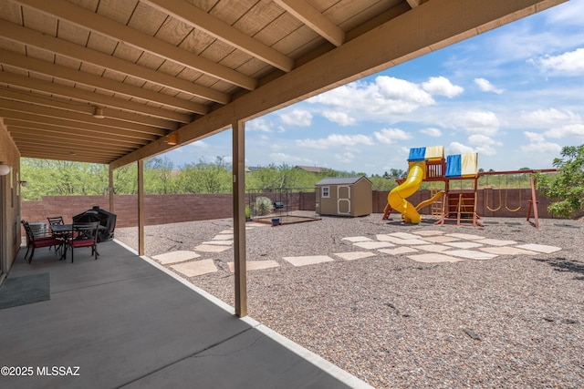 977 S Limestone St, Benson, AZ 85602 - fenced backyard featuring a storage unit, a playground, and a patio