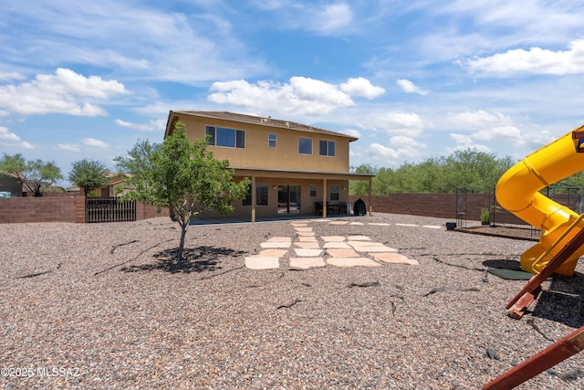 977 S Limestone St, Benson, AZ 85602 - back of property with a playground, a fenced backyard, stucco siding, and a patio