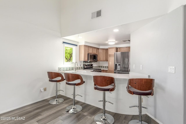467 S Stephanie Loop, Tucson, AZ 85745 - kitchen with stainless steel appliances, wood finished floors, light countertops, a peninsula, and recessed lighting