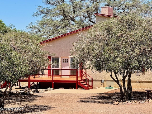 10487 E Turkey Creek Rd, Pearce, AZ 85625 - back of property with a wooden deck, a chimney, and stucco siding