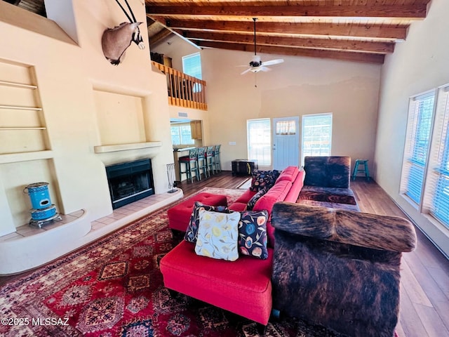 10487 E Turkey Creek Rd, Pearce, AZ 85625 - living room featuring ceiling fan, wood finished floors, a tile fireplace, a wooden ceiling with exposed beams, and high vaulted ceiling