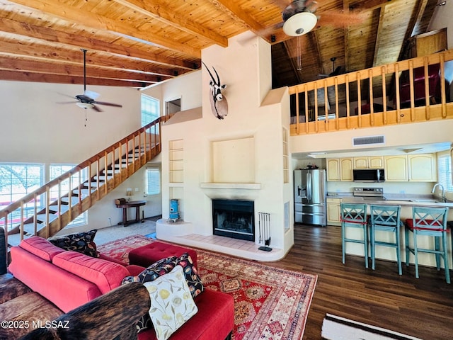 10487 E Turkey Creek Rd, Pearce, AZ 85625 - living area with ceiling fan, stairway, a high ceiling, a wood ceiling with exposed beams, and a tile fireplace