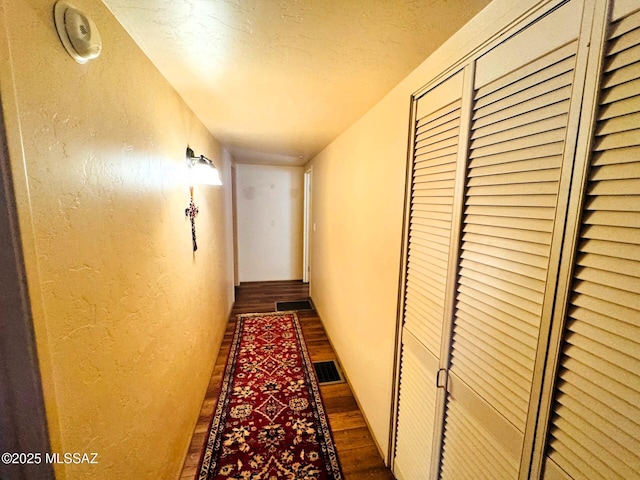 10487 E Turkey Creek Rd, Pearce, AZ 85625 - hallway featuring dark wood-style flooring, a textured wall, and a textured ceiling