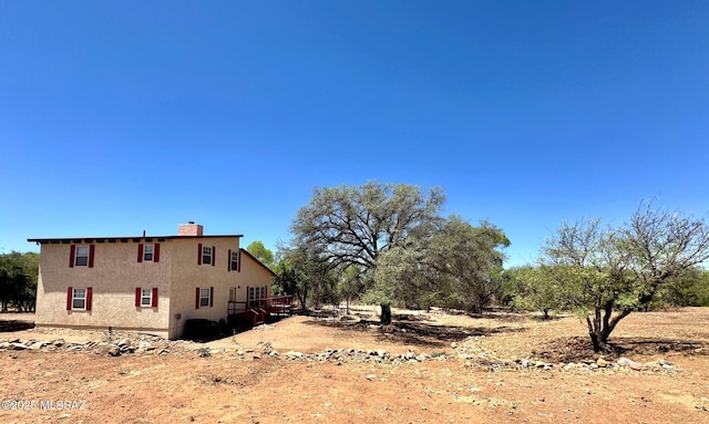 10487 E Turkey Creek Rd, Pearce, AZ 85625 - view of side of home featuring stucco siding and a chimney