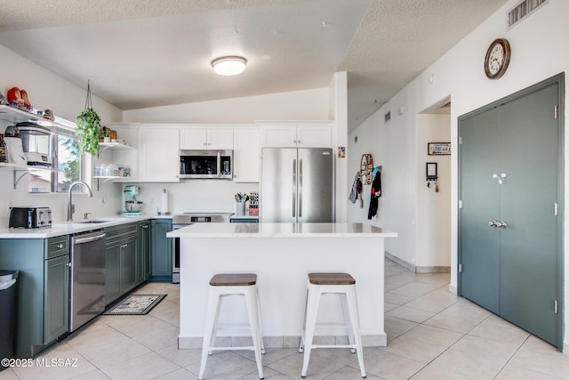 6075 N Applesauce Ct, Tucson, AZ 85741 - kitchen with stainless steel appliances, open shelves, a breakfast bar area, light countertops, and white cabinets