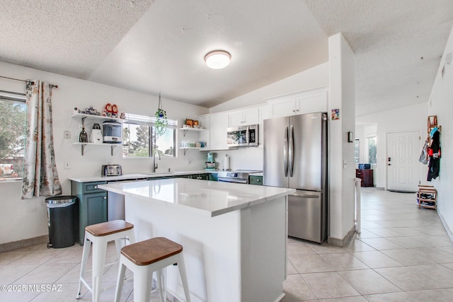 6075 N Applesauce Ct, Tucson, AZ 85741 - kitchen with appliances with stainless steel finishes, open shelves, vaulted ceiling, a textured ceiling, and light tile patterned flooring