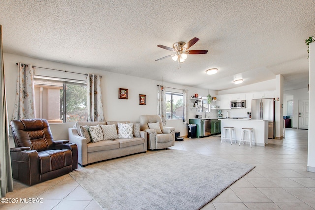 6075 N Applesauce Ct, Tucson, AZ 85741 - living room featuring light tile patterned floors, ceiling fan, a textured ceiling, and lofted ceiling