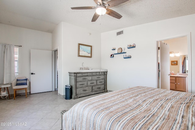 6075 N Applesauce Ct, Tucson, AZ 85741 - bedroom with light tile patterned floors, a textured ceiling, ensuite bath, and a ceiling fan
