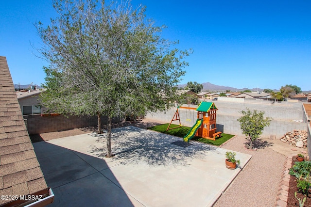 6075 N Applesauce Ct, Tucson, AZ 85741 - fenced backyard featuring a playground, a patio, and a mountain view