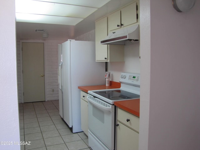 1001 E Irene St, Pearce, AZ 85625 - kitchen featuring white range with electric cooktop, under cabinet range hood, light tile patterned floors, light countertops, and cream cabinets