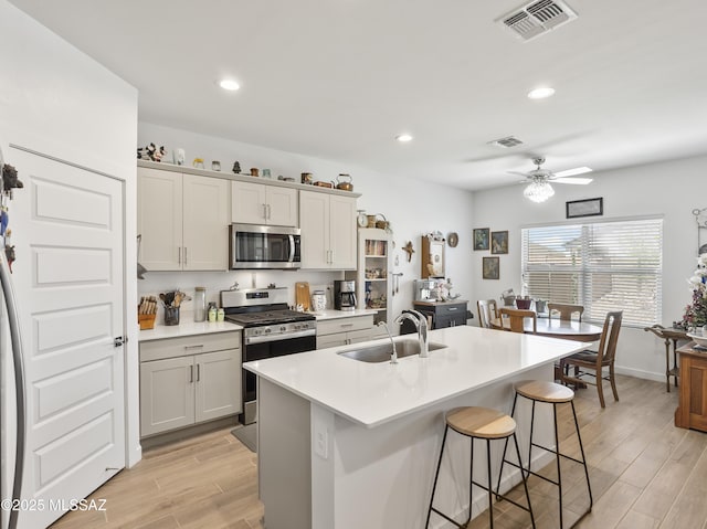 656 W Wilkinson St, Corona De Tucson, AZ 85641 - kitchen featuring stainless steel appliances, a kitchen breakfast bar, light wood-style flooring, a kitchen island with sink, and light countertops