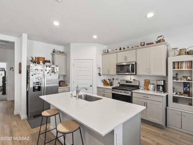 656 W Wilkinson St, Corona De Tucson, AZ 85641 - kitchen with stainless steel appliances, light wood-style floors, a kitchen breakfast bar, light countertops, and gray cabinetry