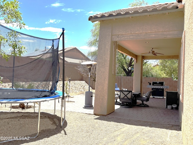 1102 E Mud Spring Canyon Ln, Sahuarita, AZ 85629 - fenced backyard with a trampoline, a patio, area for grilling, and ceiling fan