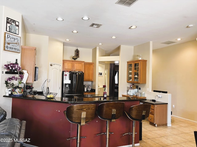 1102 E Mud Spring Canyon Ln, Sahuarita, AZ 85629 - kitchen featuring fridge with ice dispenser, a peninsula, light tile patterned floors, recessed lighting, and a breakfast bar