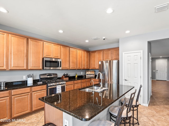 11471 E Squash Blossom Loop, Tucson, AZ 85747 - kitchen with stainless steel appliances, recessed lighting, light tile patterned floors, a breakfast bar area, and dark stone counters