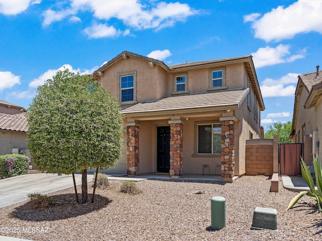 11471 E Squash Blossom Loop, Tucson, AZ 85747 - traditional home featuring a gate, stucco siding, a tiled roof, stone siding, and a porch
