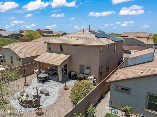 11471 E Squash Blossom Loop, Tucson, AZ 85747 - back of property featuring an outdoor fire pit, stucco siding, a patio, solar panels, and a residential view