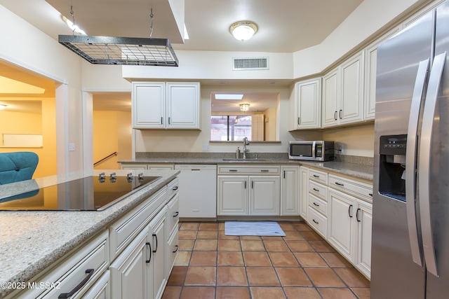 2000 E Campbell Ter, Tucson, AZ 85718 - kitchen with appliances with stainless steel finishes, tile patterned flooring, white cabinetry, and light countertops