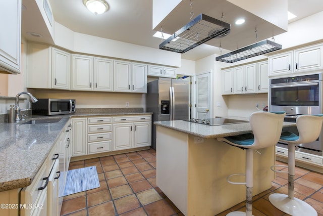 2000 E Campbell Ter, Tucson, AZ 85718 - kitchen featuring appliances with stainless steel finishes, a center island, a breakfast bar, light stone countertops, and light tile patterned floors