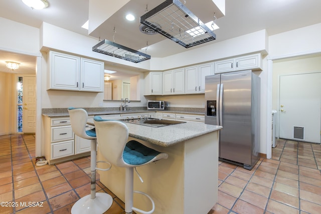 2000 E Campbell Ter, Tucson, AZ 85718 - kitchen with stainless steel appliances, a center island, light tile patterned floors, and white cabinets