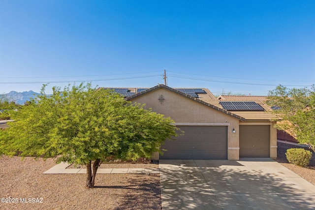 10235 E Placita De Dos Pesos, Tucson, AZ 85730 - view of front of property with a garage, driveway, stucco siding, roof mounted solar panels, and a tiled roof