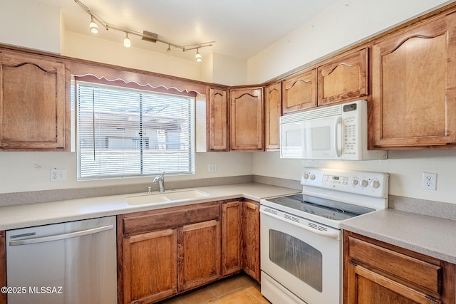 2366 N Camino Mateo, Tucson, AZ 85745 - kitchen featuring white appliances, brown cabinetry, light tile patterned floors, and light countertops
