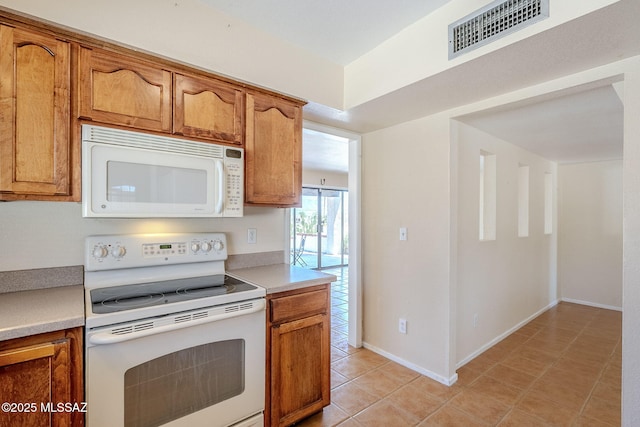 2366 N Camino Mateo, Tucson, AZ 85745 - kitchen featuring white appliances, light countertops, brown cabinets, and light tile patterned floors